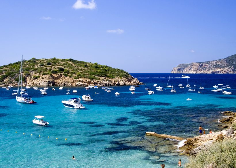 sun in mallorca beach with boats